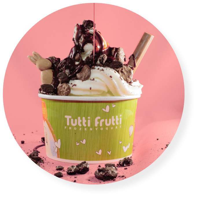 Copa de frozen yogurt Tutti Frutti con toppings de chocolate.