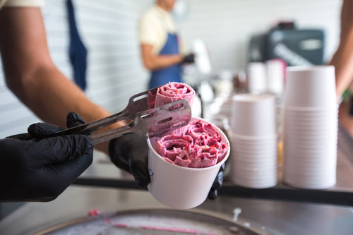 Preparando helado enrollado de frutos rojos en vaso